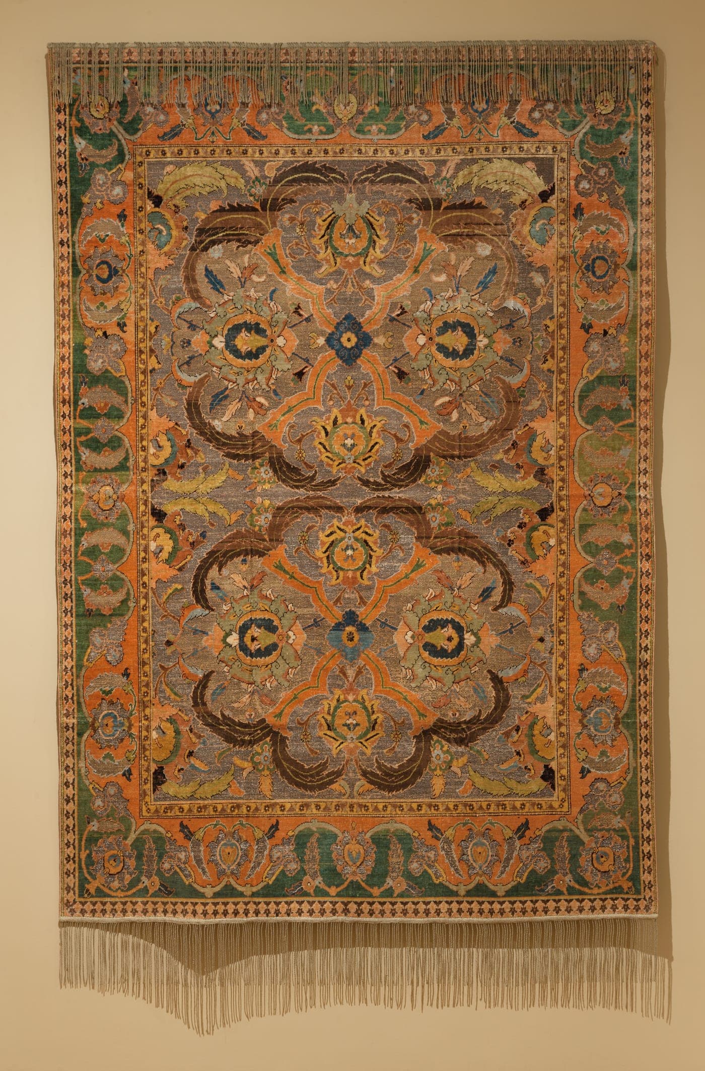 A large court carpet with a deep field of scrolling vines and palmettes, worked in silk and metal-wrapped thread, the pattern continuing without repetition across the full width.