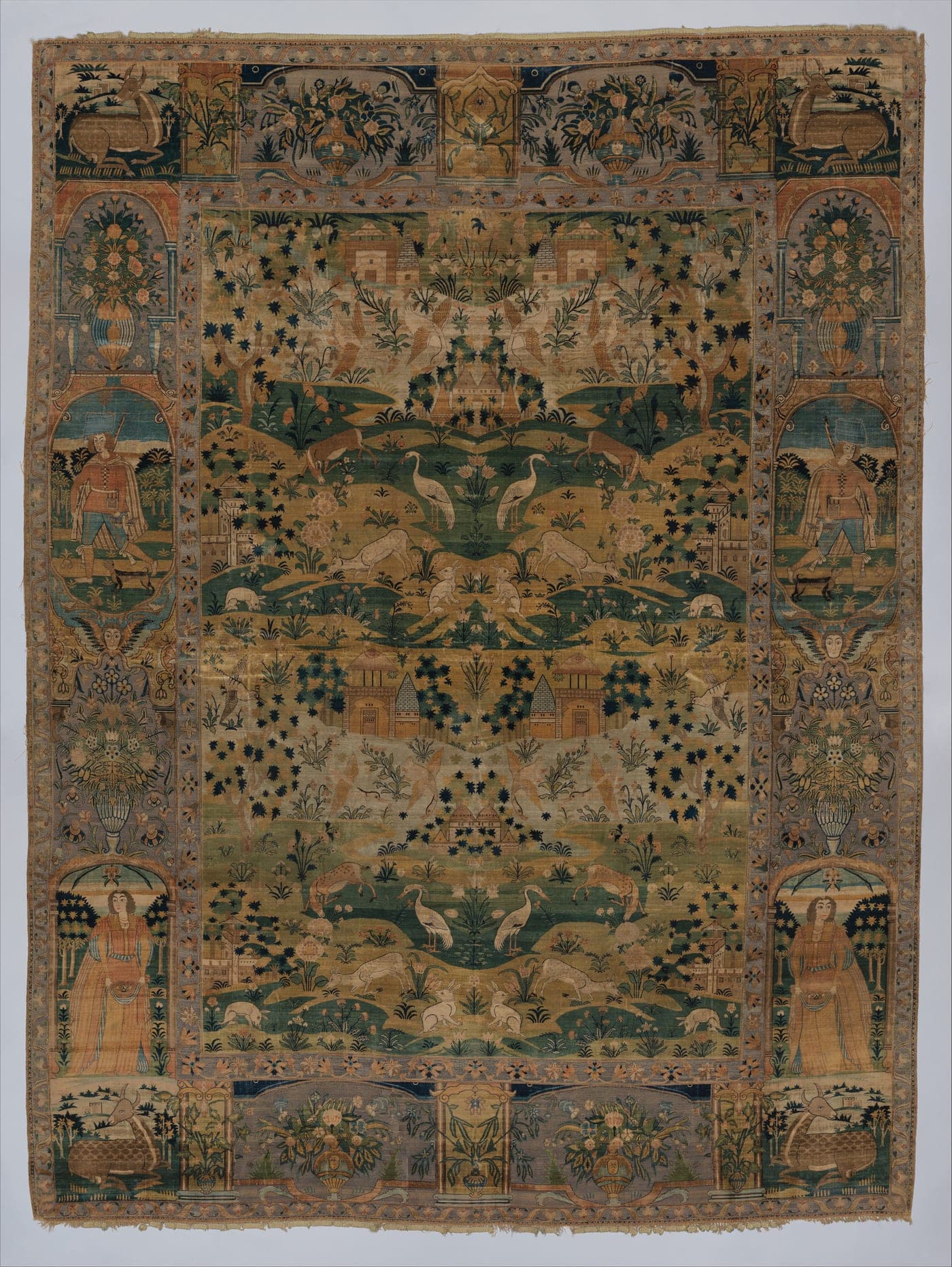 A 17th-century Persian carpet showing figures and animals in a landscape, rendered with shading and overlapping forms rather than as flat repeated motifs.
