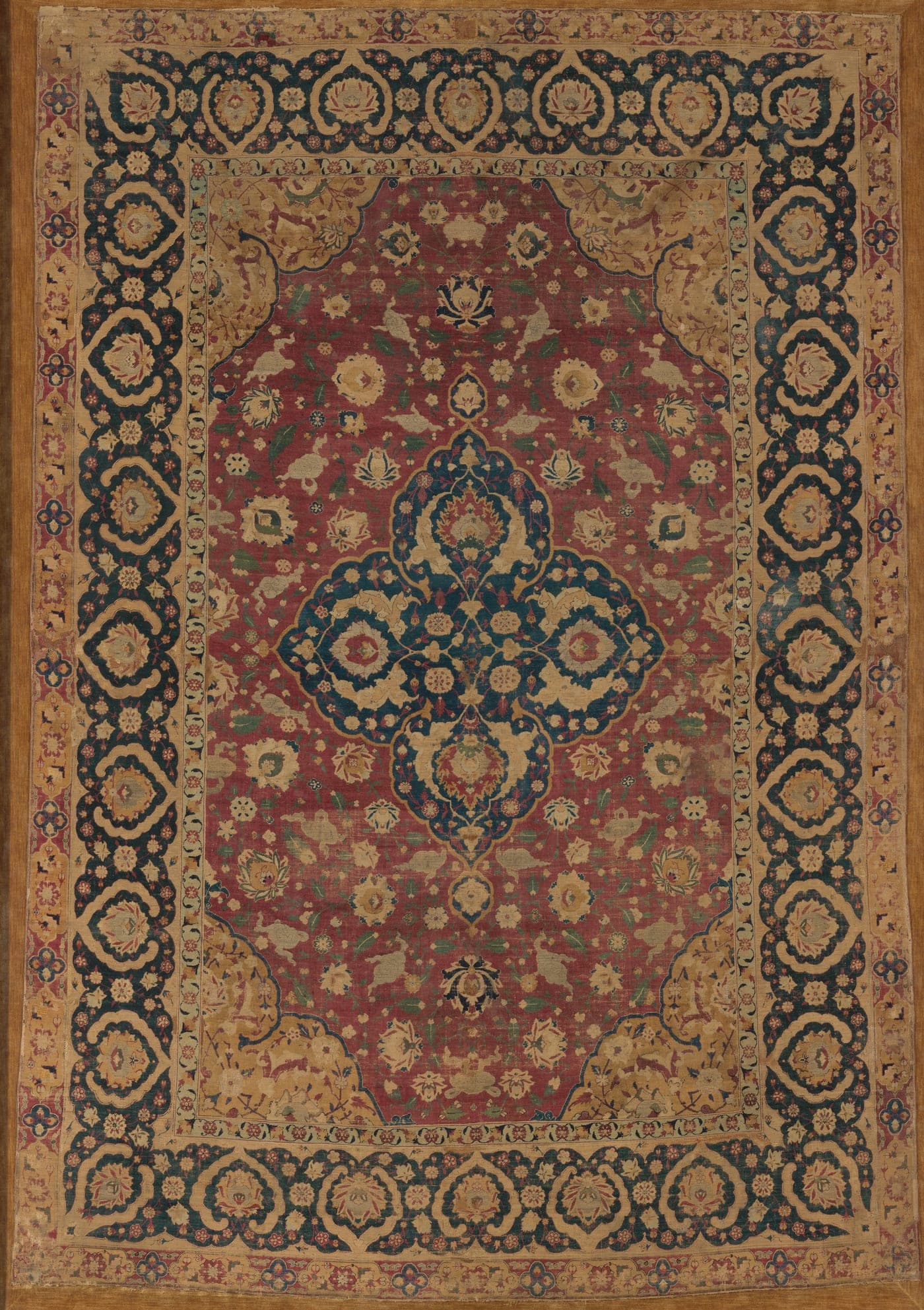 A silk Kashan carpet with a central lobed medallion on a deep red field of scrolling vines, with matching quarter-medallions in each corner.